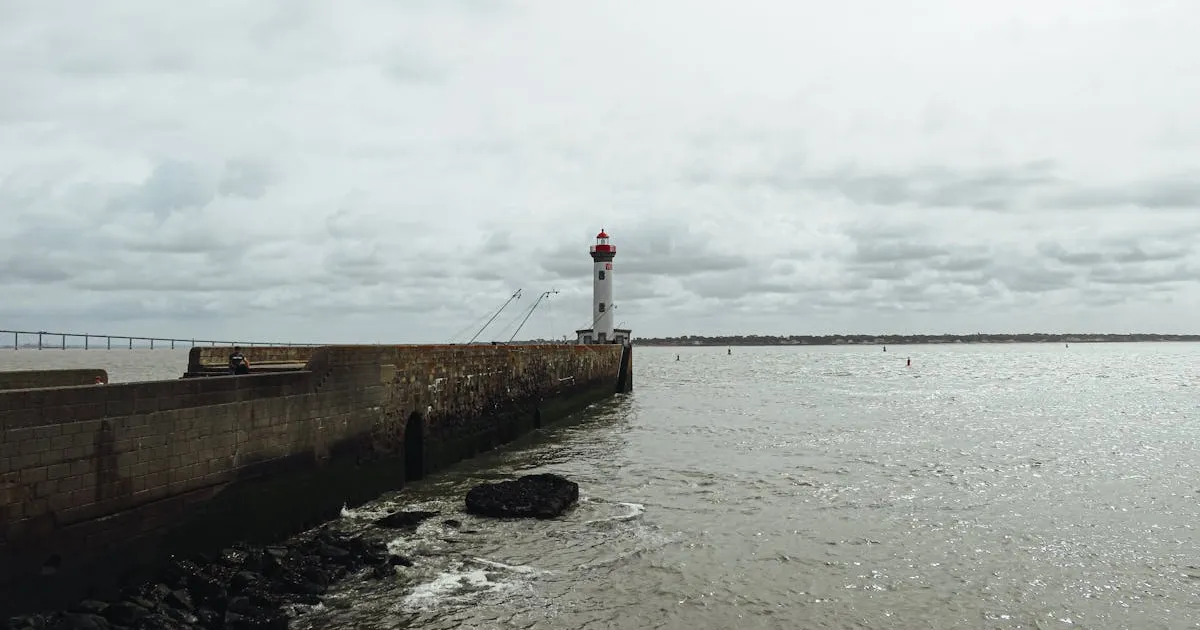 2月の曇り空の港 - 灯台のある堤防と冬の海