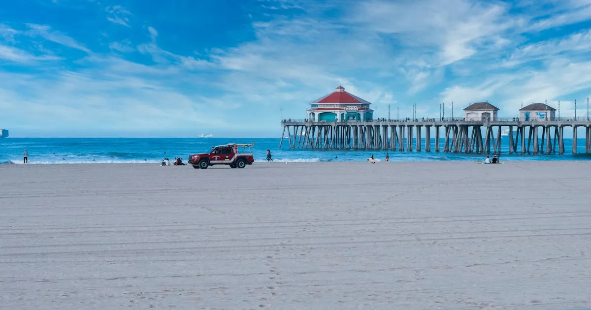 7月の夏のビーチ - 青空の下の桟橋と賑わう海水浴場