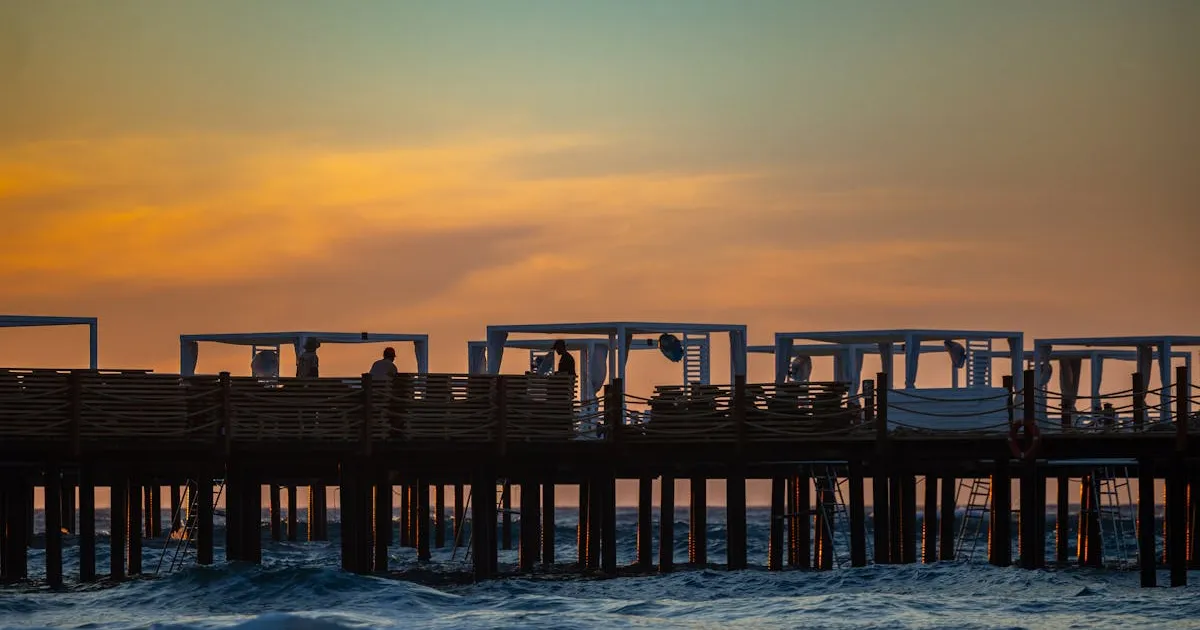 11月の晩秋の夕焼け - 桟橋のシルエットとオレンジ色の空